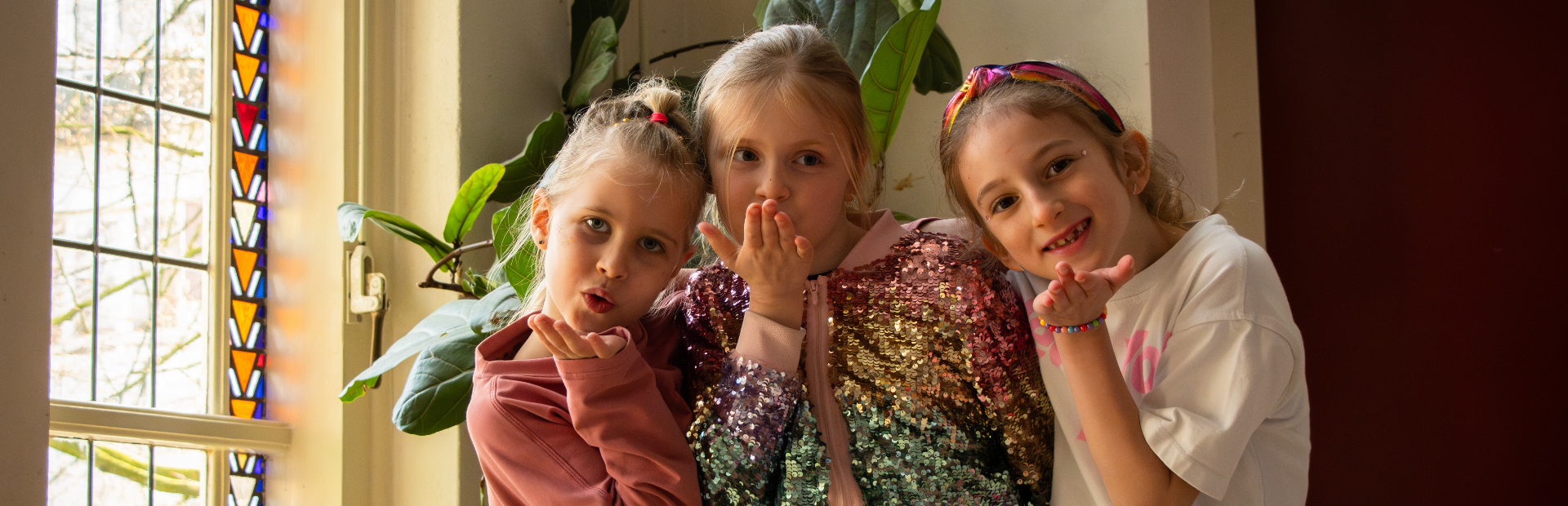 Drie kinderen van musicalschool Stars2Go samen met een kushandje